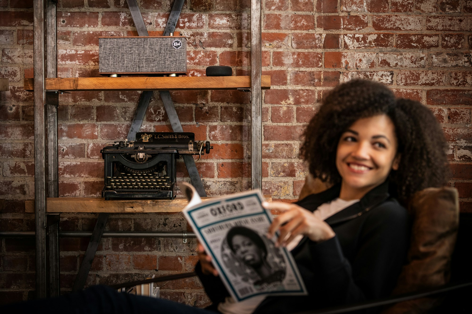 Woman reads a magazine while listening to a speaker